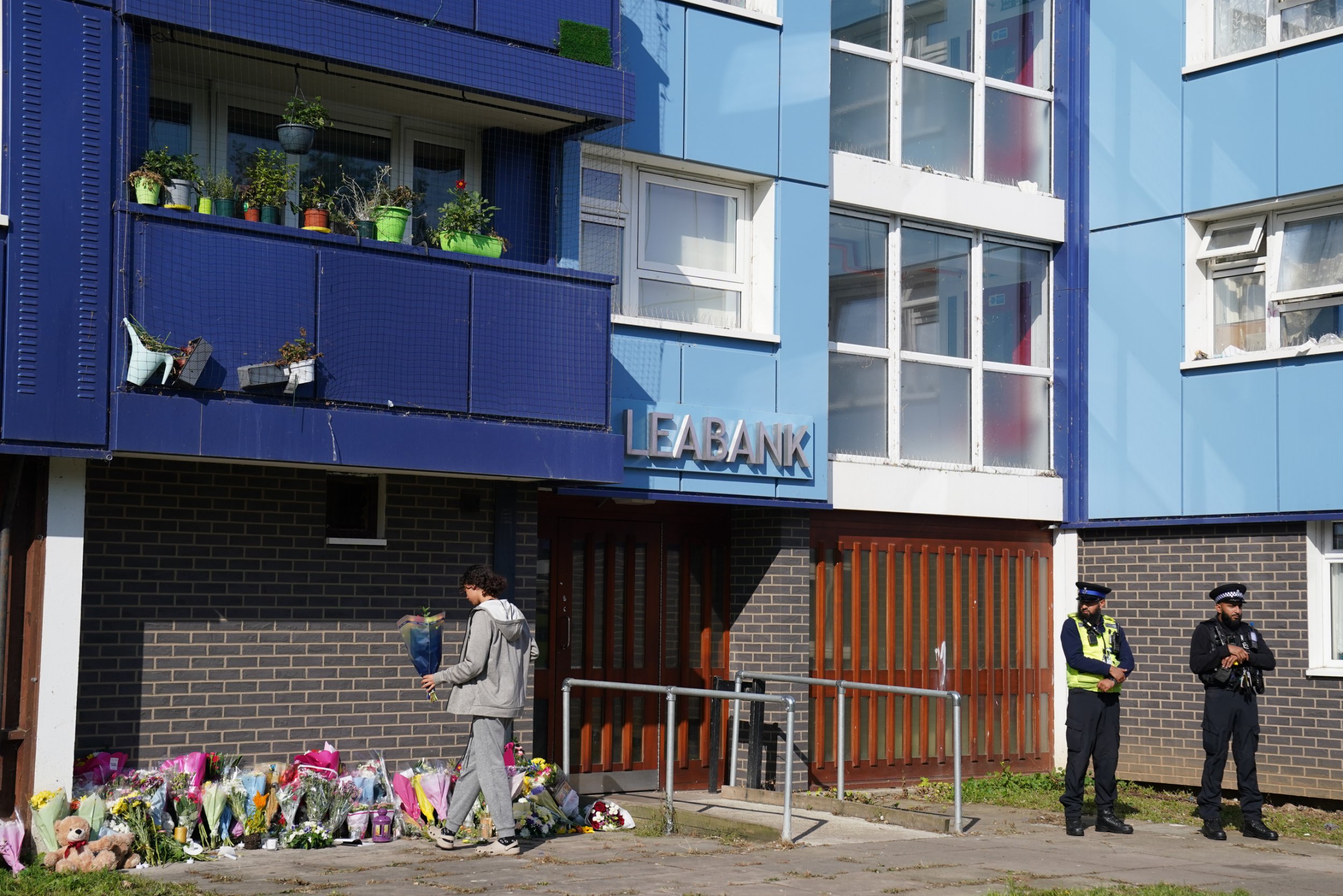 A person lays flowers at Leabank, Luton, Bedfordshire, where three people, believed to be Juliana Prosper, 48, Kyle Prosper, 16, and Giselle Prosper, 13, although formal identification has yet to take place, were found dead in a flat in Leabank, off Wauluds Bank Drive, at around 5.30am on Friday. Nicholas Prosper, 18, of Leabank, Luton, has been charged with the murders of the woman and the two teenagers Bedfordshire Police said. Picture date: Sunday September 15, 2024. PA Photo. See PA story POLICE Leabank. Photo credit should read: Jacob King/PA Wire