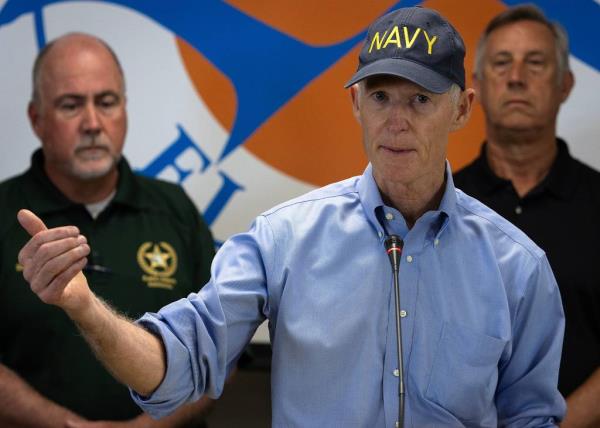 Sen. Rick Scott (R-Fla.) holding a microphone, addressing Bay County residents about Hurricane Helene at the Emergency Operations Center